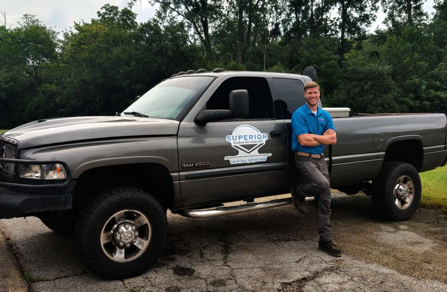 Owner of Superior Outdoor Services LLC standing proud with equipment, ready to serve Dayton, Ohio